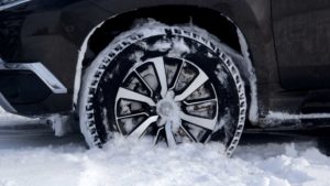 Pneu avec jante de voiture dans la neige.